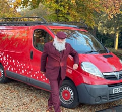 Mr Claus presenting a gift at a private home visit